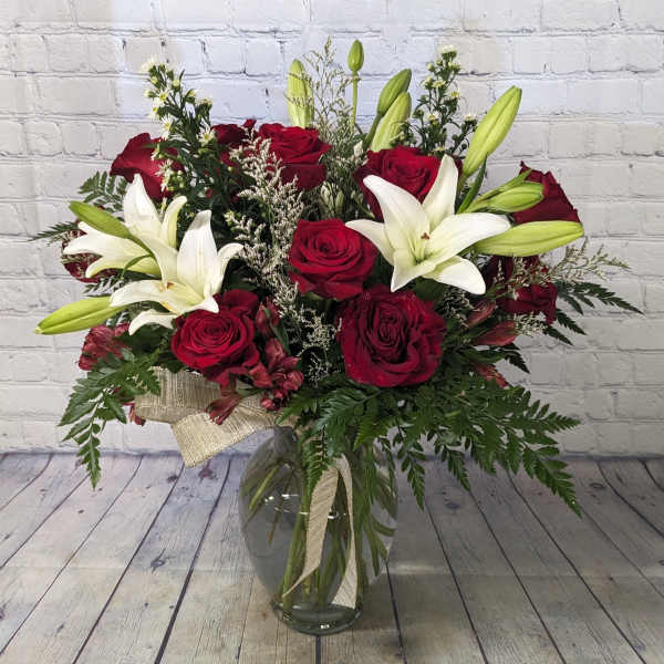 Bouquet of red roses and white lilies in a glass vase