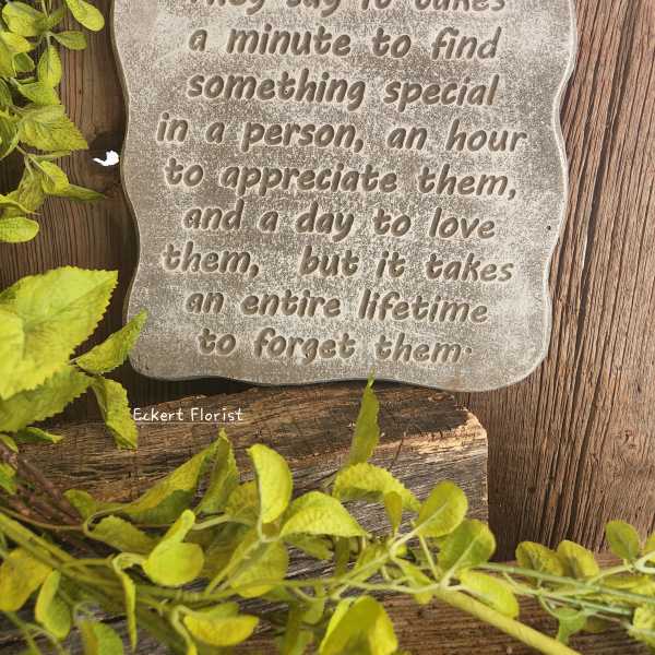 Decorative stone plaque with a quote on a wood background