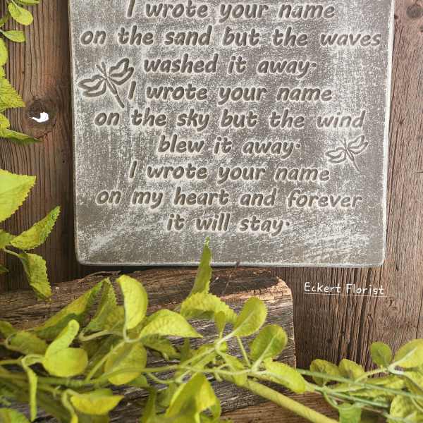 Decorative memorial plaque with a sentimental quote on a wood background