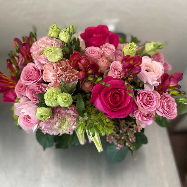Bouquet of pink and magenta roses with green and peach blooms