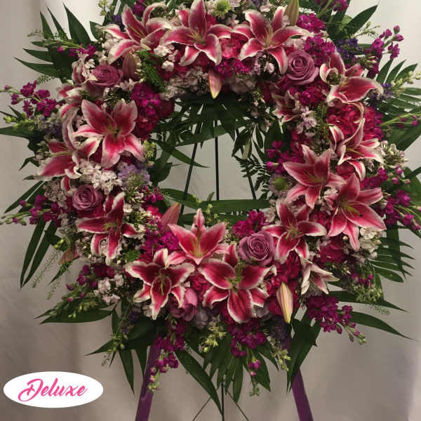 Large pink and white lily wreath with roses on a stand