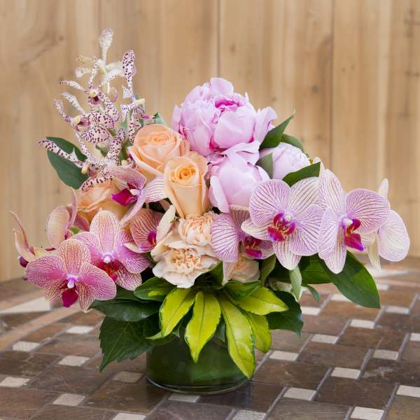 Pink and peach flowers arranged in a glass vase