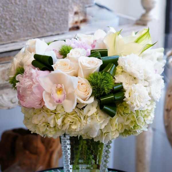 White and blush floral arrangement in a clear glass vase