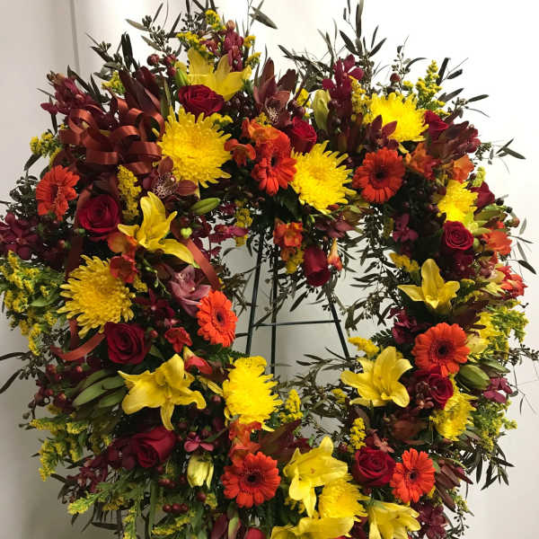 Heart-shaped floral wreath with red, yellow, and orange blooms