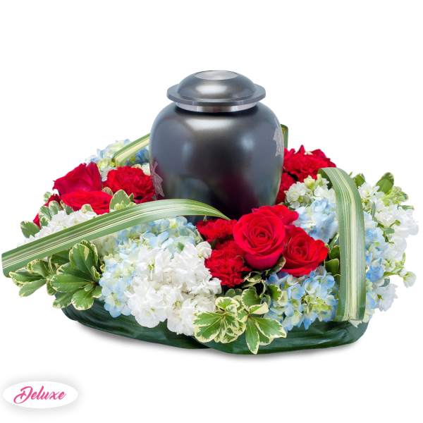Floral urn arrangement with red roses, blue and white hydrangeas, and a black urn
