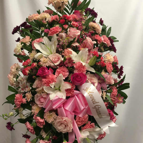 Large pink and white standing floral spray with a ribbon