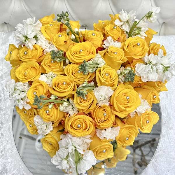 Heart-shaped bouquet of yellow roses and white flowers