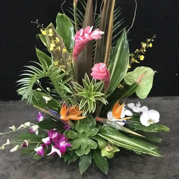 Tropical floral arrangement with pink ginger, orchids, and bird of paradise