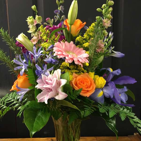 Mixed bouquet of colorful flowers in a clear glass vase