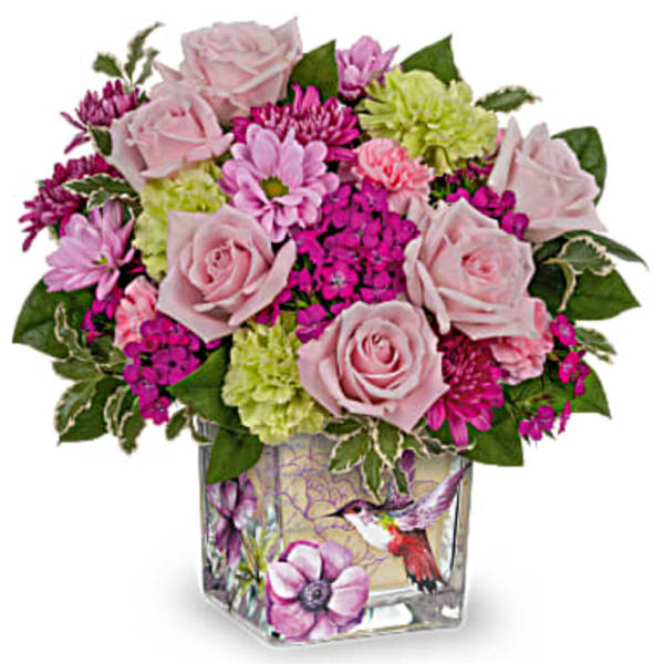 Pink roses and mixed blooms in a square glass vase with bird artwork