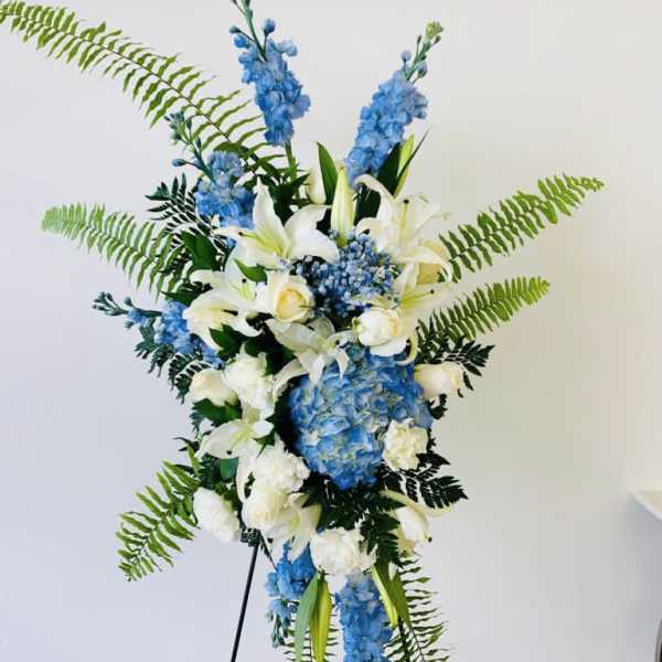 Tall blue and white floral standing arrangement on an easel