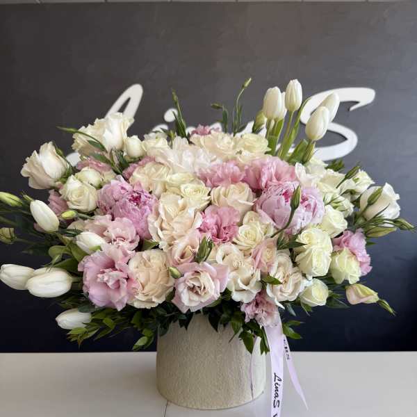 Pink and white floral arrangement in a textured cream vase