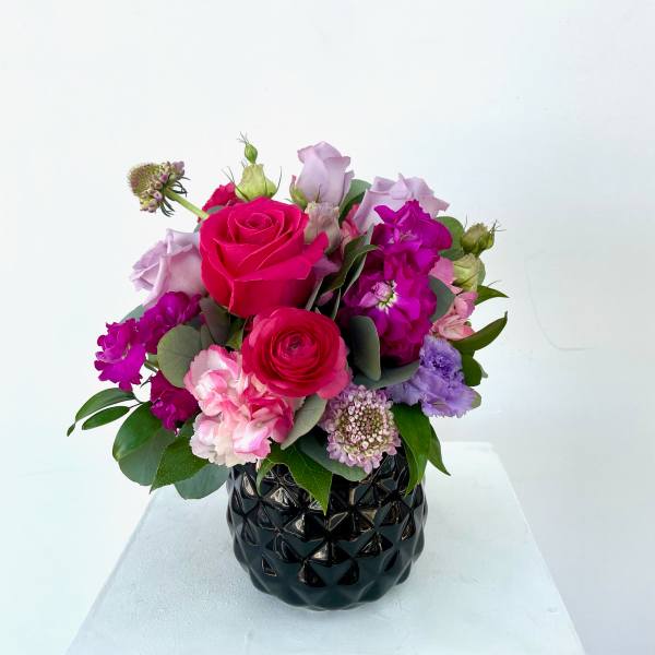 Pink and lavender bouquet in a black vase