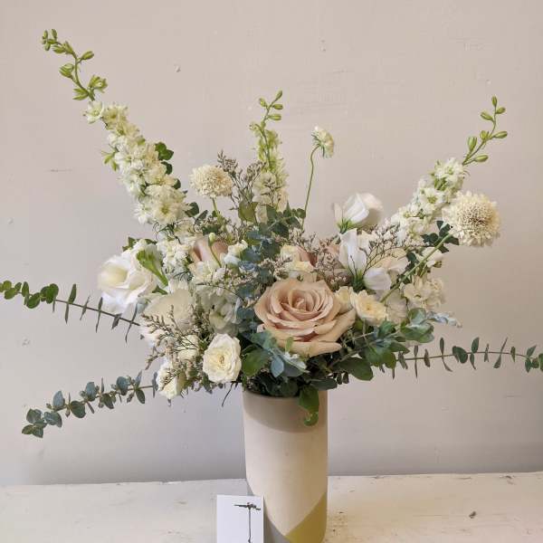 White and blush floral arrangement in a tall vase