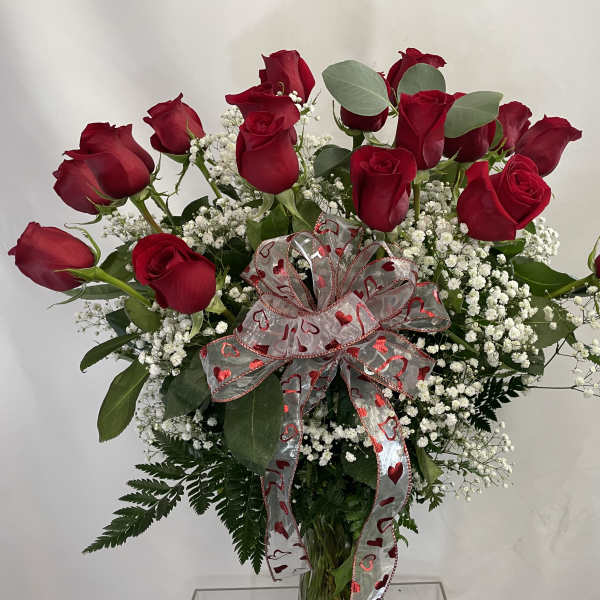 Bouquet of red roses with baby's breath and a heart-patterned ribbon