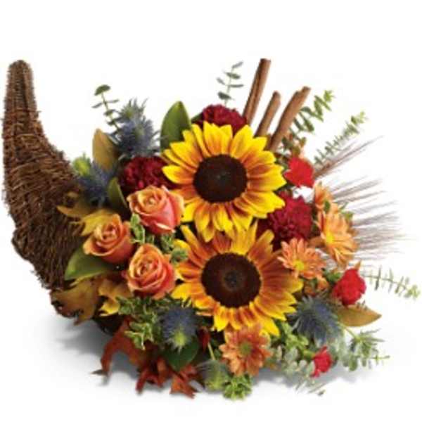 Autumn cornucopia arrangement with yellow sunflowers, orange roses, and red blooms in a wicker horn basket