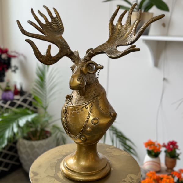 Bronze moose bust sculpture with large antlers on a round table