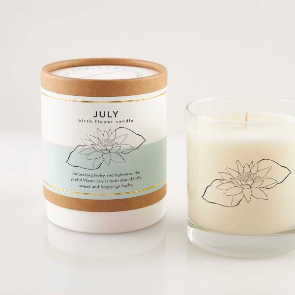 Two lily-themed candles, one in a labeled box and one in a glass jar