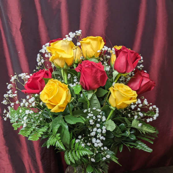 Bouquet of red and yellow roses in a glass vase