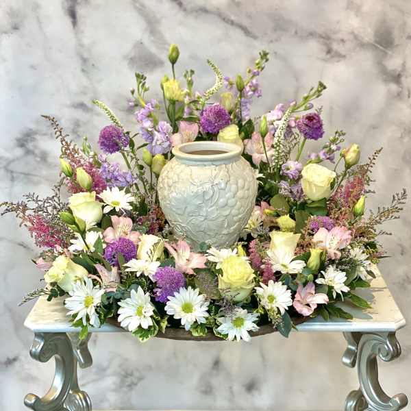 Pastel floral arrangement around a decorative ceramic urn