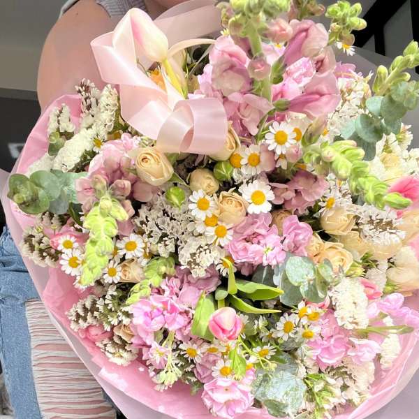 Bouquet of pink and cream flowers wrapped in pink paper