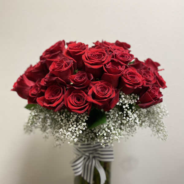 Bouquet of red roses with white baby's breath in a glass vase
