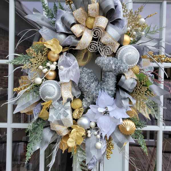 Decorative holiday wreath with silver, gold, and white ribbons and ornaments