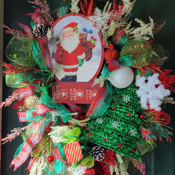 Christmas wreath with Santa sign, ribbons, pinecones, and ornaments