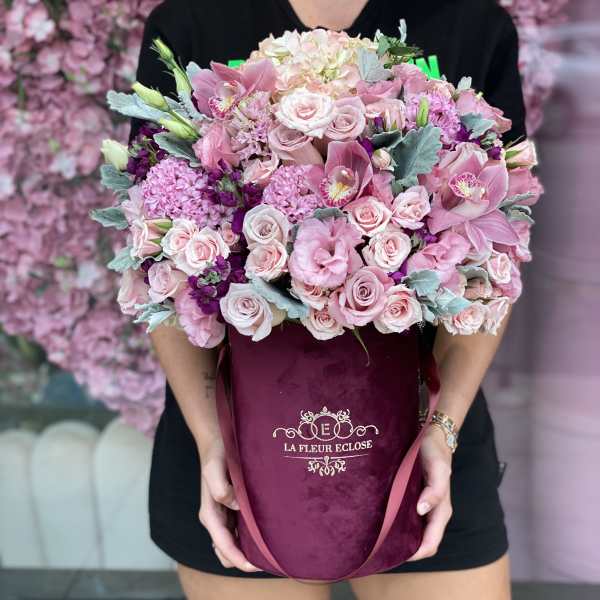 Large pink bouquet in a burgundy hatbox with ribbon handles