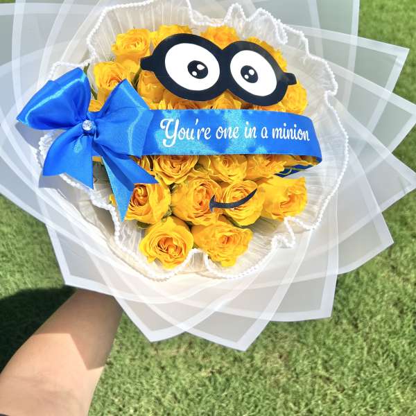 Yellow rose bouquet with a blue ribbon and cartoon glasses decoration