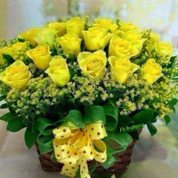Yellow roses arranged in a basket with a yellow polka-dot bow