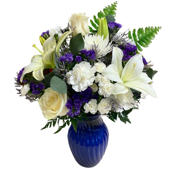 White lilies and roses with purple accents in a blue vase