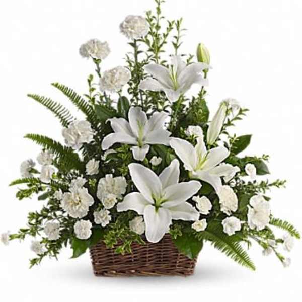 White lilies and carnations arranged in a wicker basket
