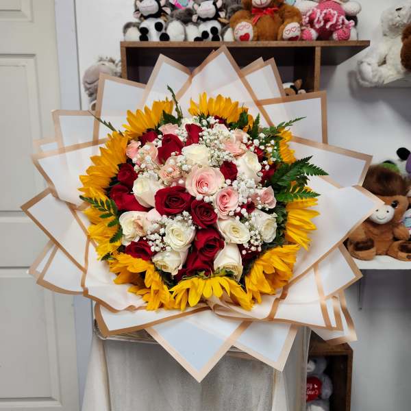Bouquet of red, pink, and white roses with yellow sunflowers