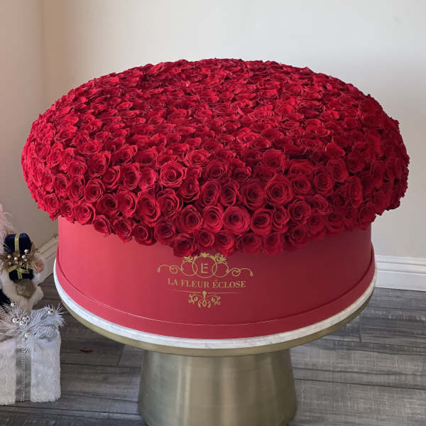 Large dome of red roses in a pink round box on a pedestal