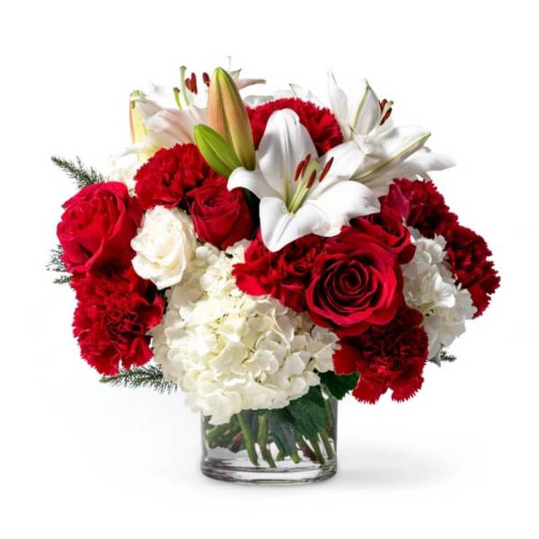 Red roses, white lilies, and white hydrangeas in a glass vase