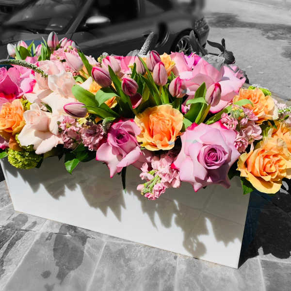Large pink and peach rose arrangement in a white box