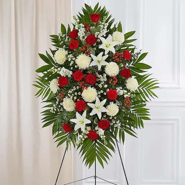Standing floral spray with red roses, white lilies, and white pompons