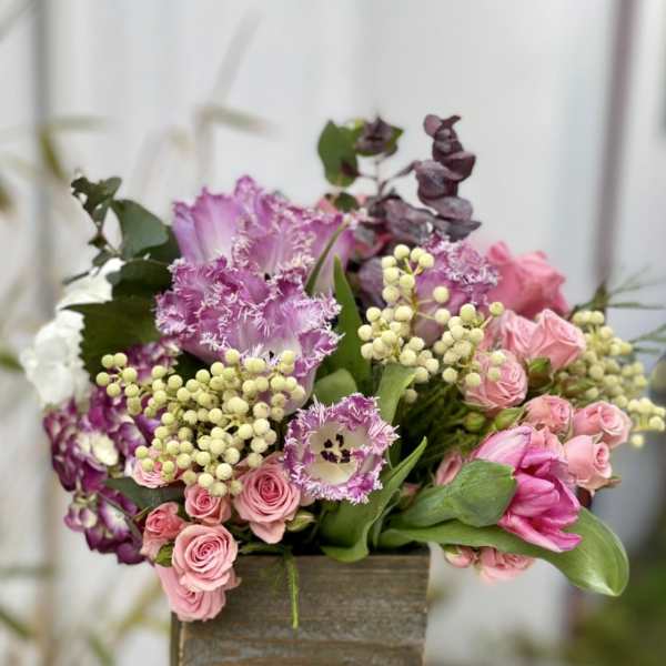 Pink and purple floral arrangement in a wooden box
