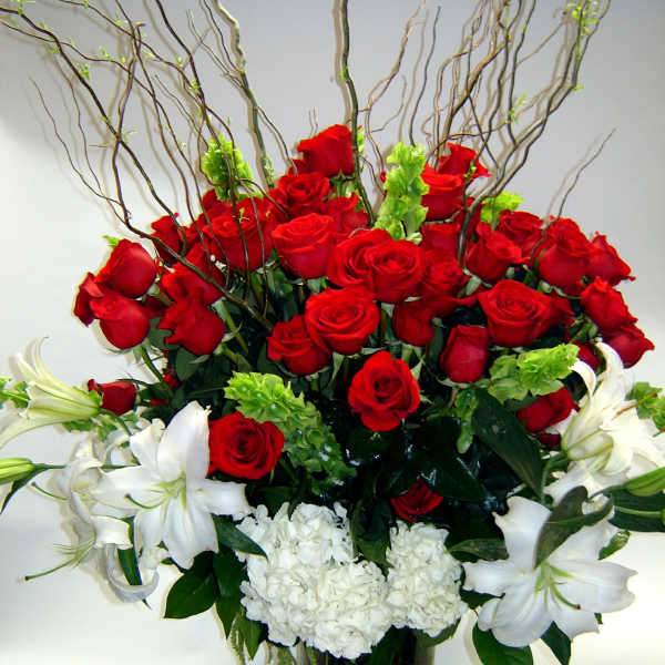 Red roses and white lilies arranged in a glass vase