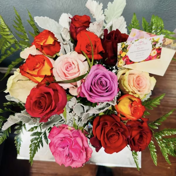 Mixed roses in a white box with fern accents