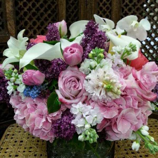 Pink and white floral arrangement in a square glass vase