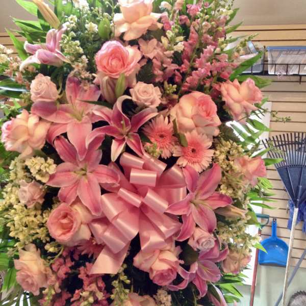 Large pink floral standing spray with a satin bow