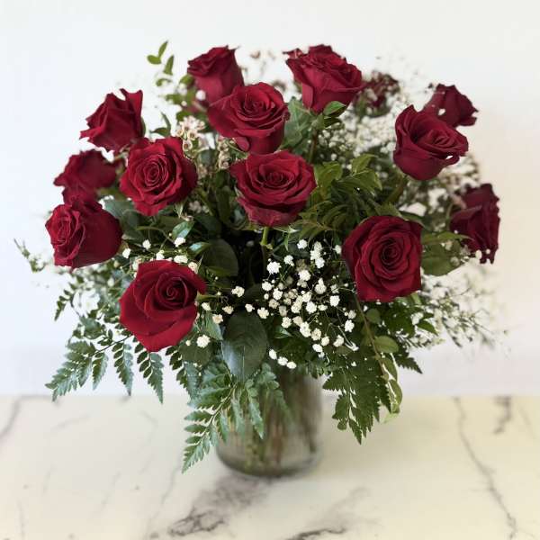 Bouquet of red roses in a glass vase with baby's breath