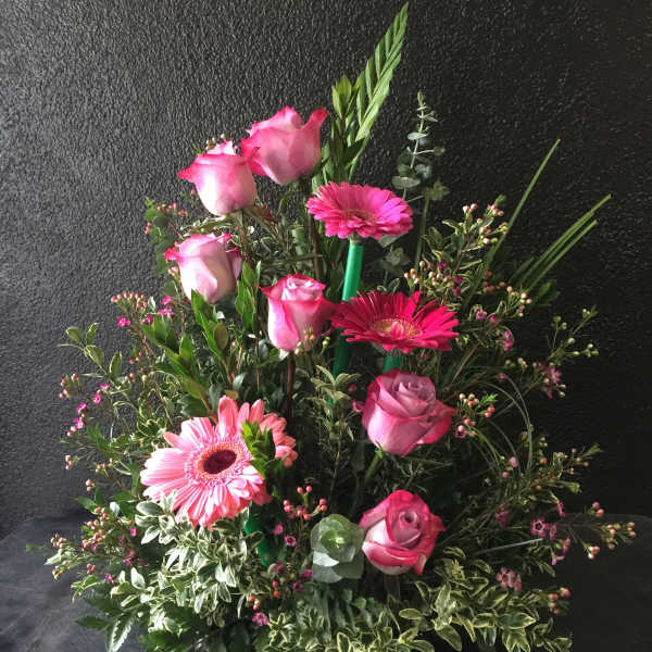 Pink roses and gerbera daisies in a lush mixed arrangement