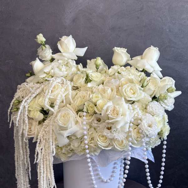 White rose arrangement in a white hatbox with pearl strands