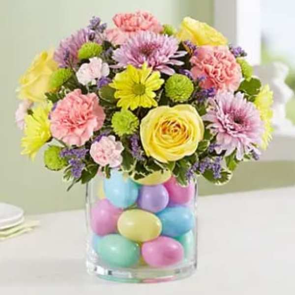 Colorful bouquet in a clear vase filled with pastel eggs