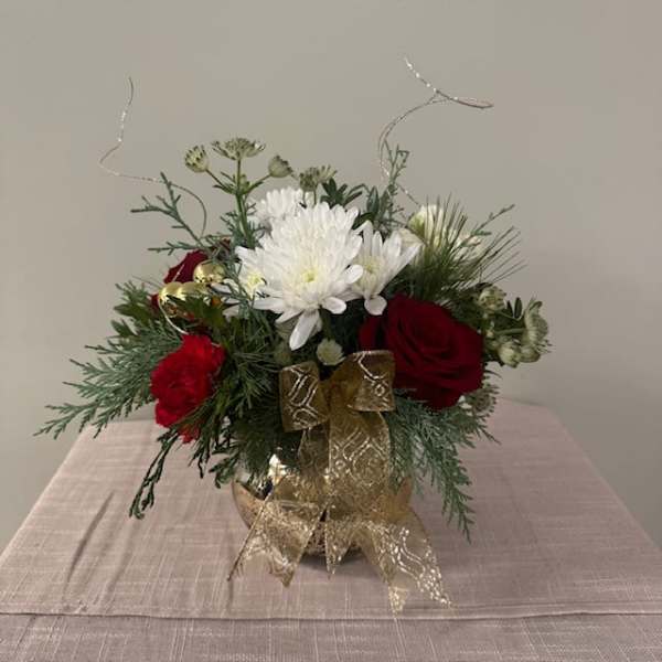 Red roses and white chrysanthemums in a gold vase with a ribbon