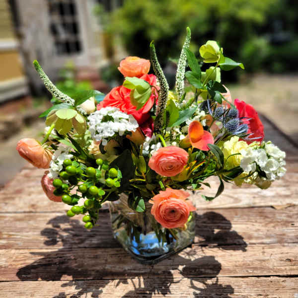 Coral and white mixed bouquet in a clear glass vase