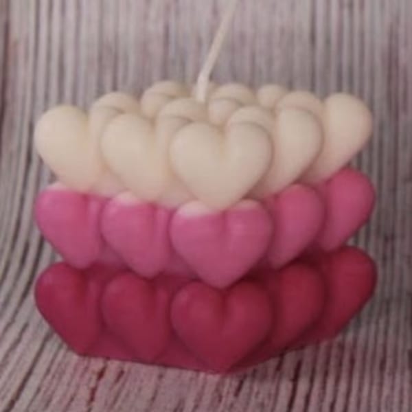 Stacked heart-shaped candles in white, pink, and red